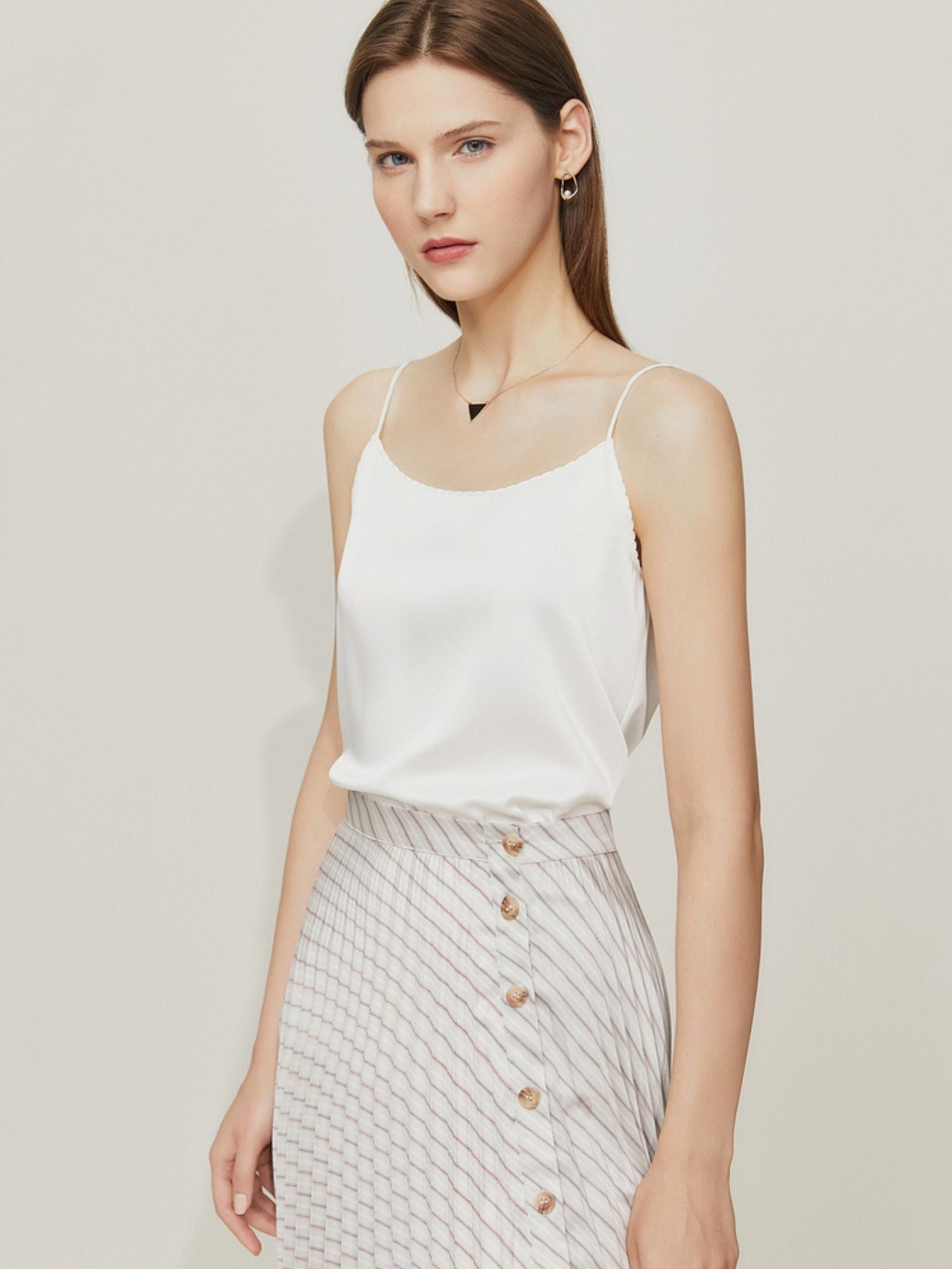 Weißes Satintop mit schmalen Trägern und kariertem Rock, frontal fotografiert