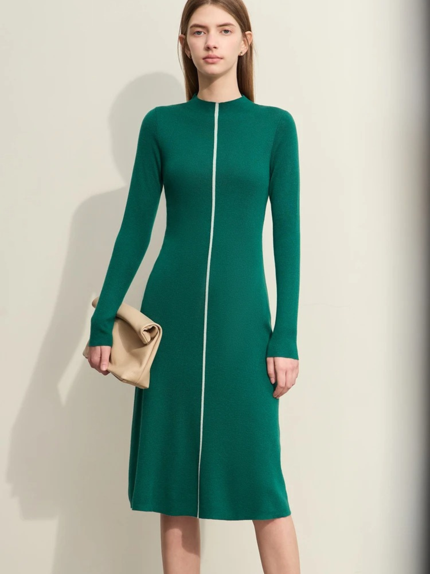 Front view of green long-sleeve knit midi dress with zip-front detail and fitted silhouette