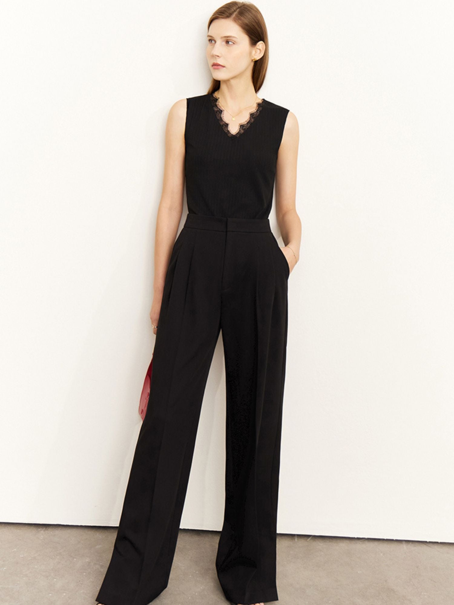 Frontalansicht des schwarzen Jumpsuits mit tiefem V-Ausschnitt und Spitze