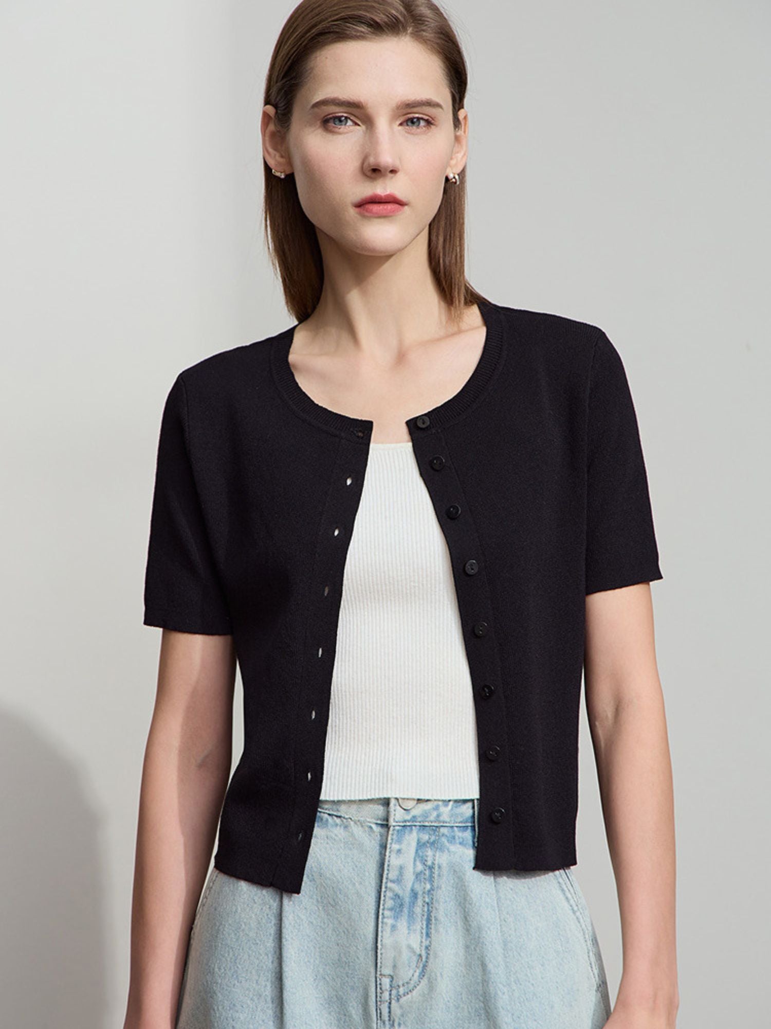 Schwarzes Stricktop mit kurzen Ärmeln und Knopfleiste, kombiniert mit blauer Hose