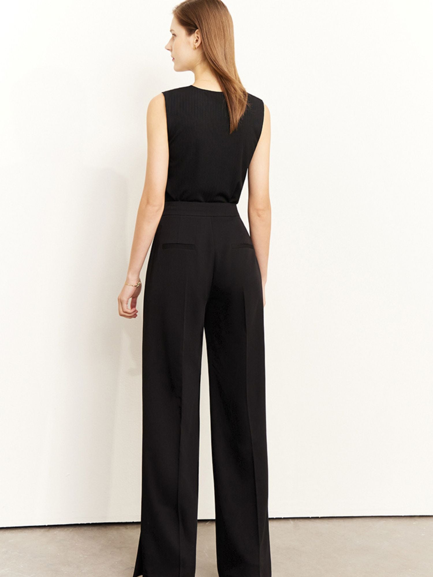 Rückansicht des schwarzen Tops mit weitem Bein und geradem Saum