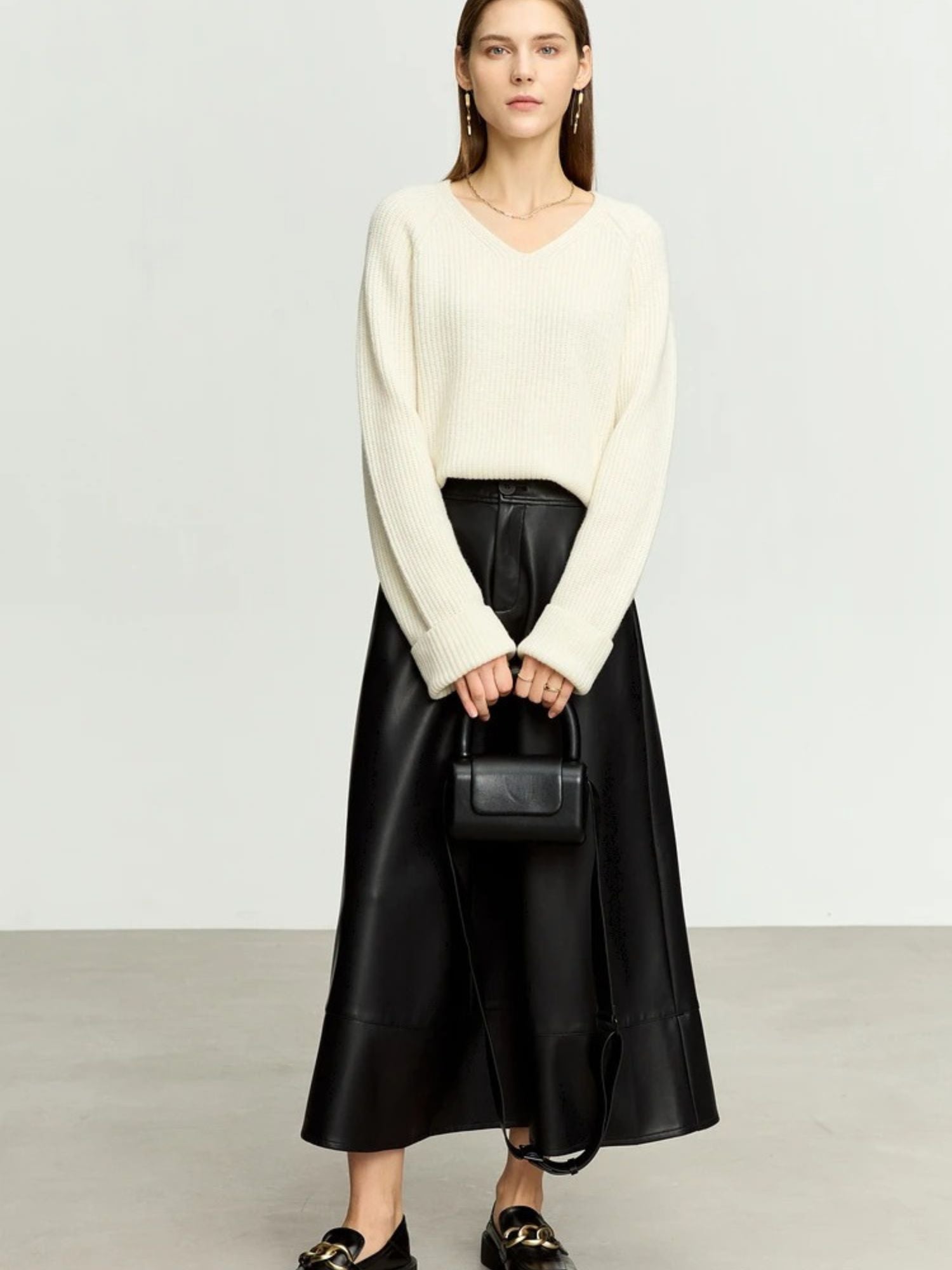 Black satin A-line midi skirt styled with ivory knit sweater and loafers