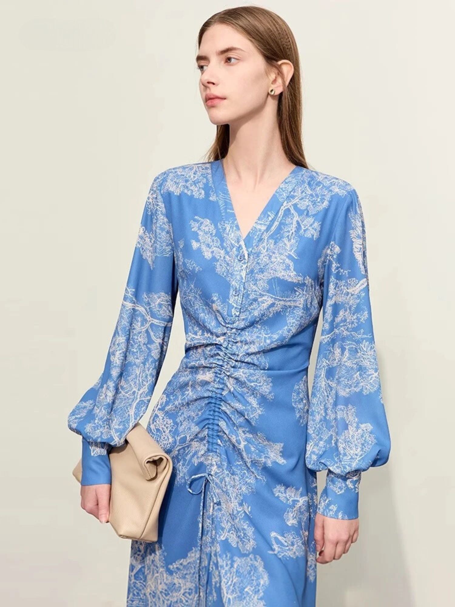 Front view of blue floral midi dress with ruched front, balloon sleeves, and v-neckline