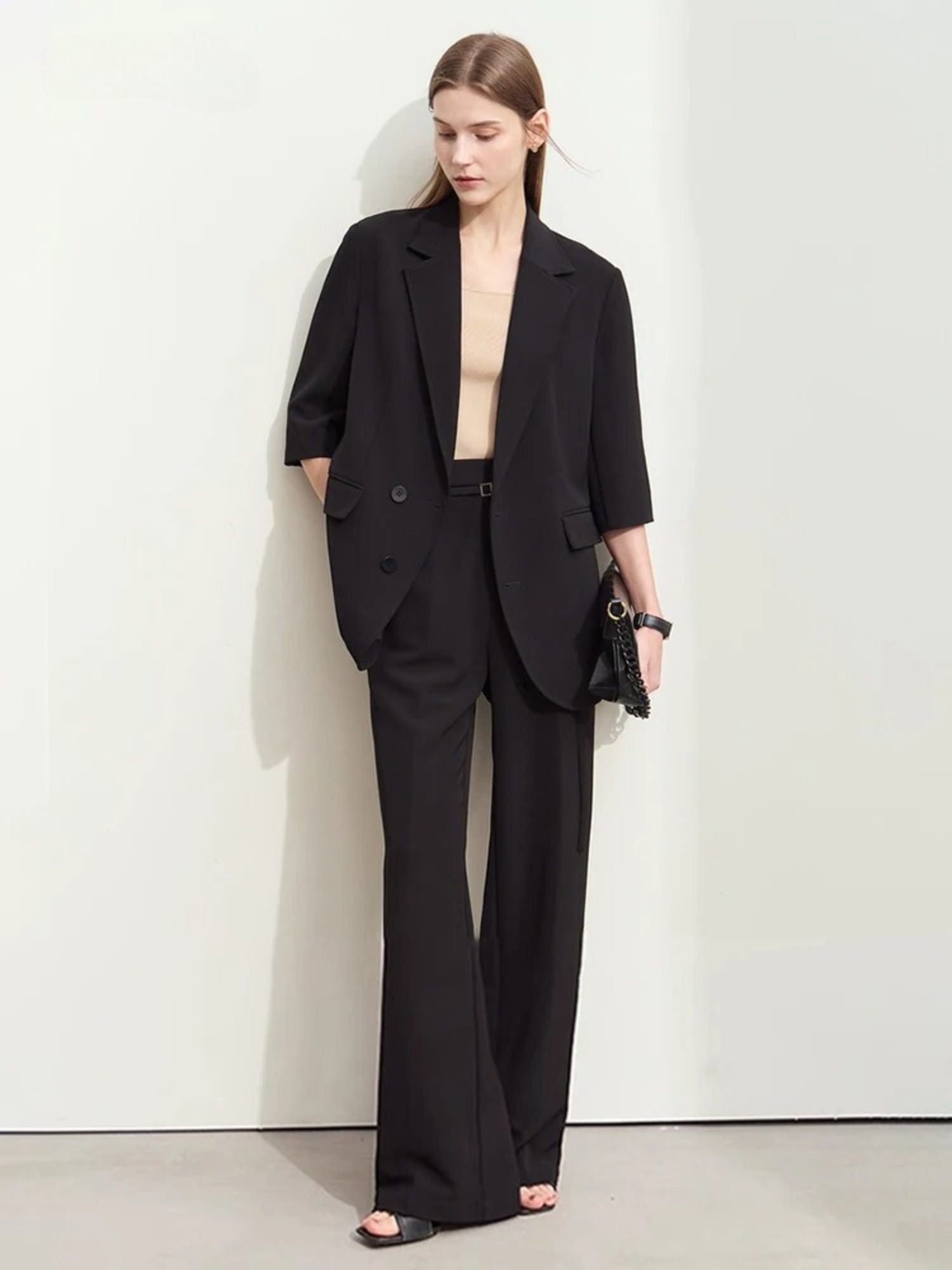 Black oversized blazer with wide-leg trousers, styled with beige top and heeled sandals


