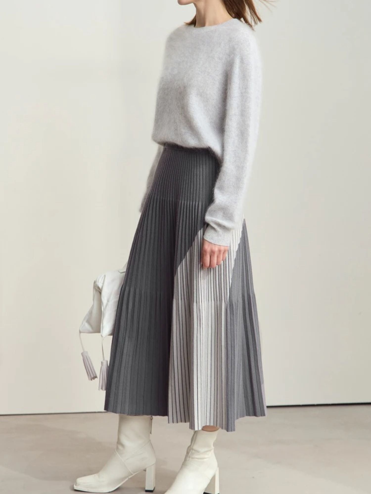 Grey and white colorblock pleated midi skirt styled with light grey sweater and white boots