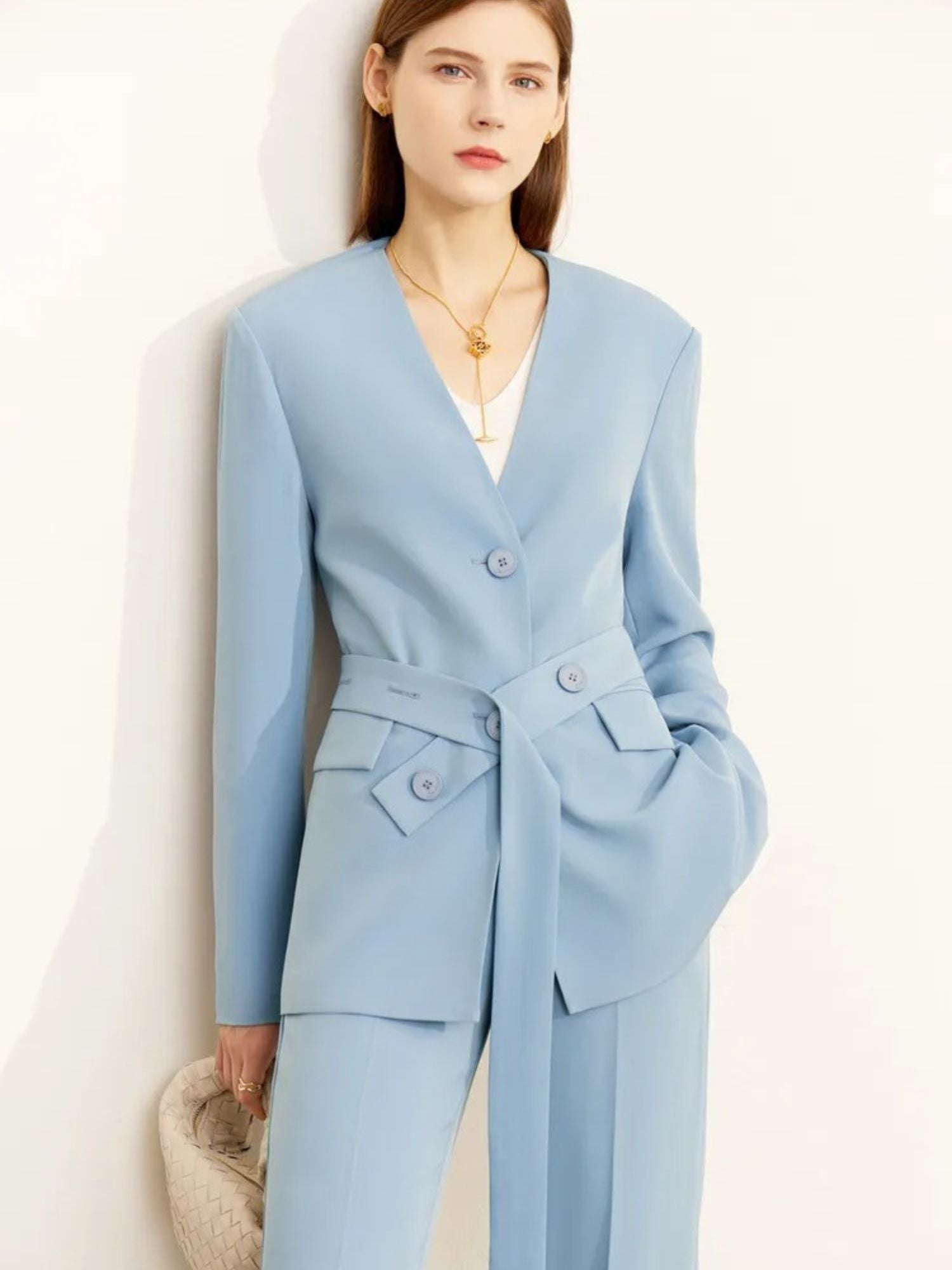 Front view of tailored light blue pantsuit with belted blazer and flap pockets