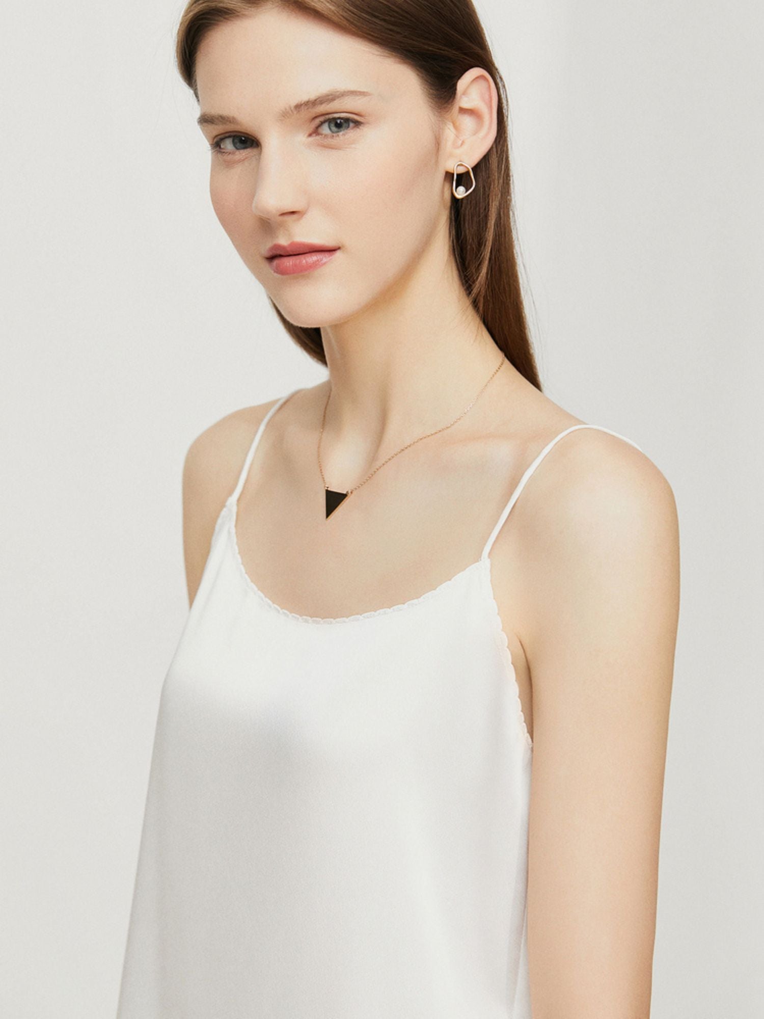 Seitenansicht des weißen Spaghettiträger-Tops mit fließendem Stoff