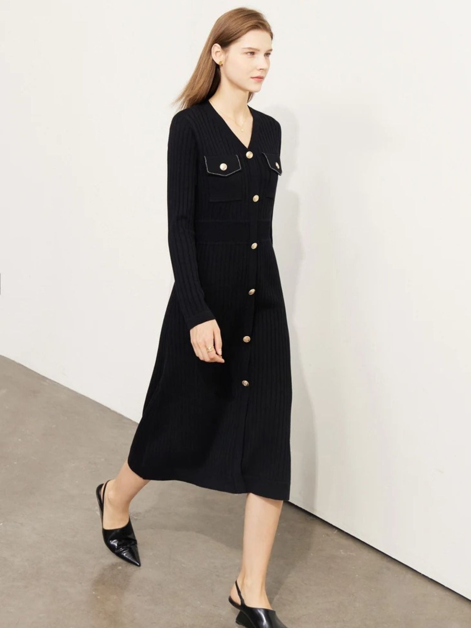 Side angle of black long-sleeve dress with button-down front and fitted silhouette