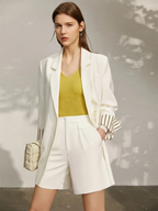 White blazer with striped sleeve lining and white shorts, worn with mustard top