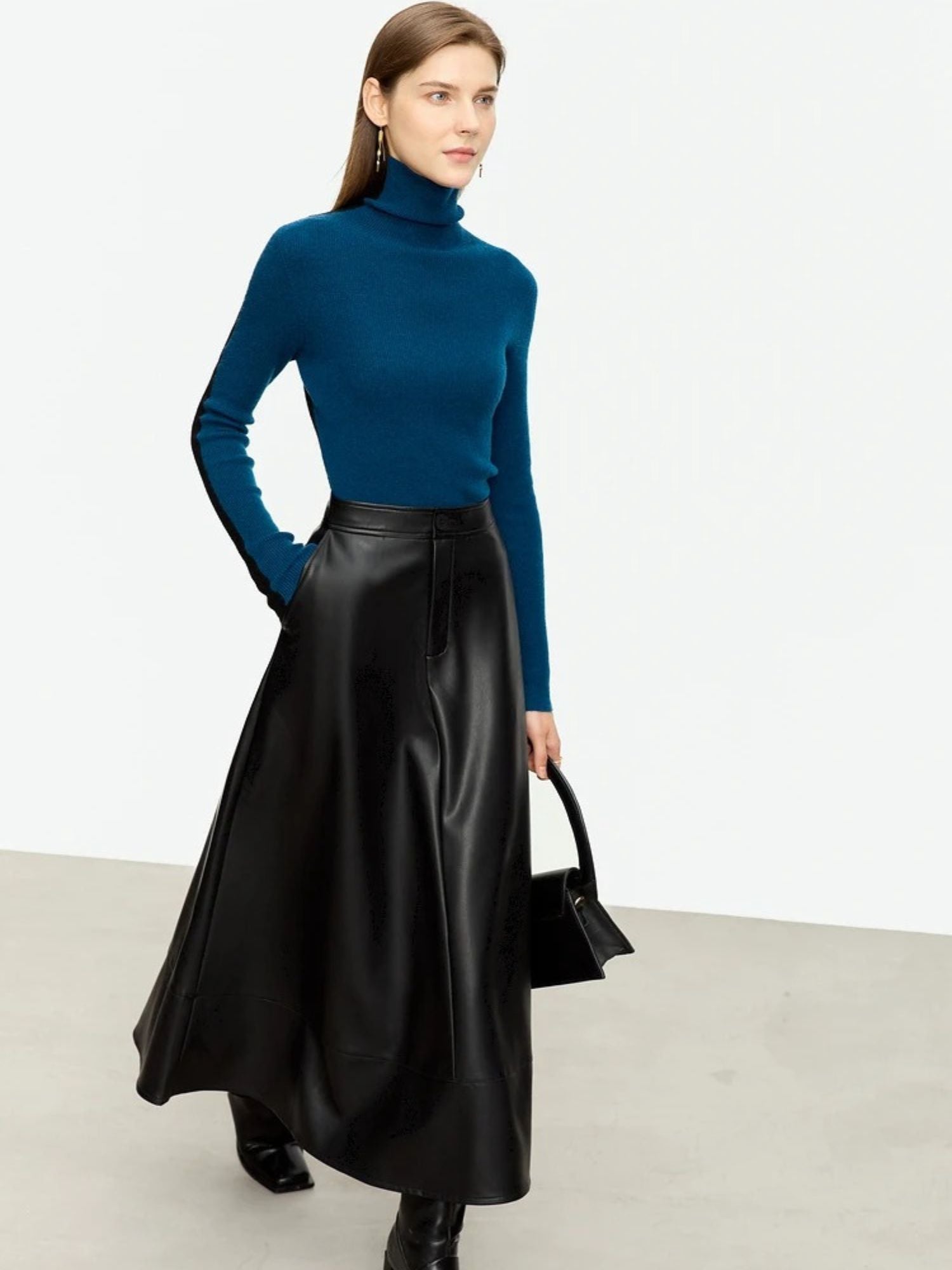 Front view of black satin skirt paired with teal long-sleeve top and heels