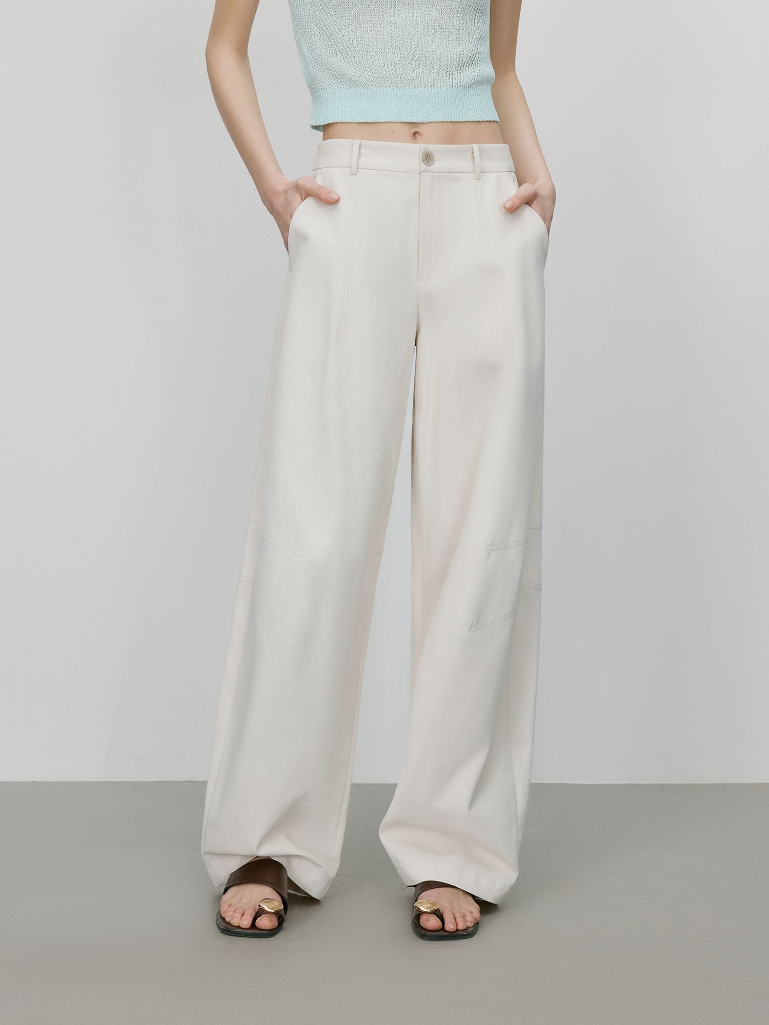 Cremefarbene Stoffhose mit weitem Bein und hoher Taille, frontal getragen