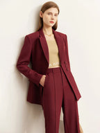 Side angle of burgundy pantsuit with peak lapel blazer and structured fit