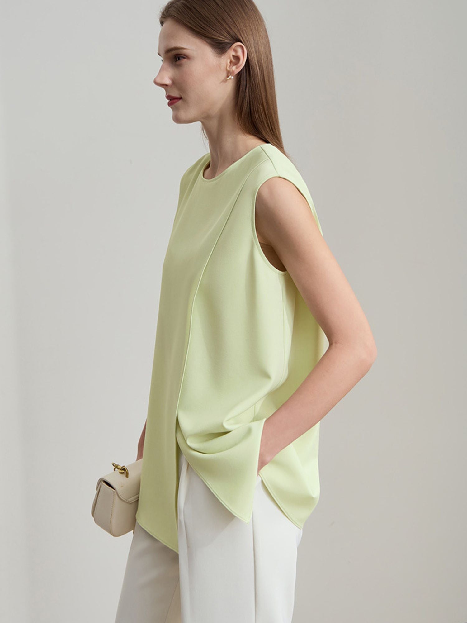Seitenansicht der hellgrünen Bluse, locker fallend über weiße Hose