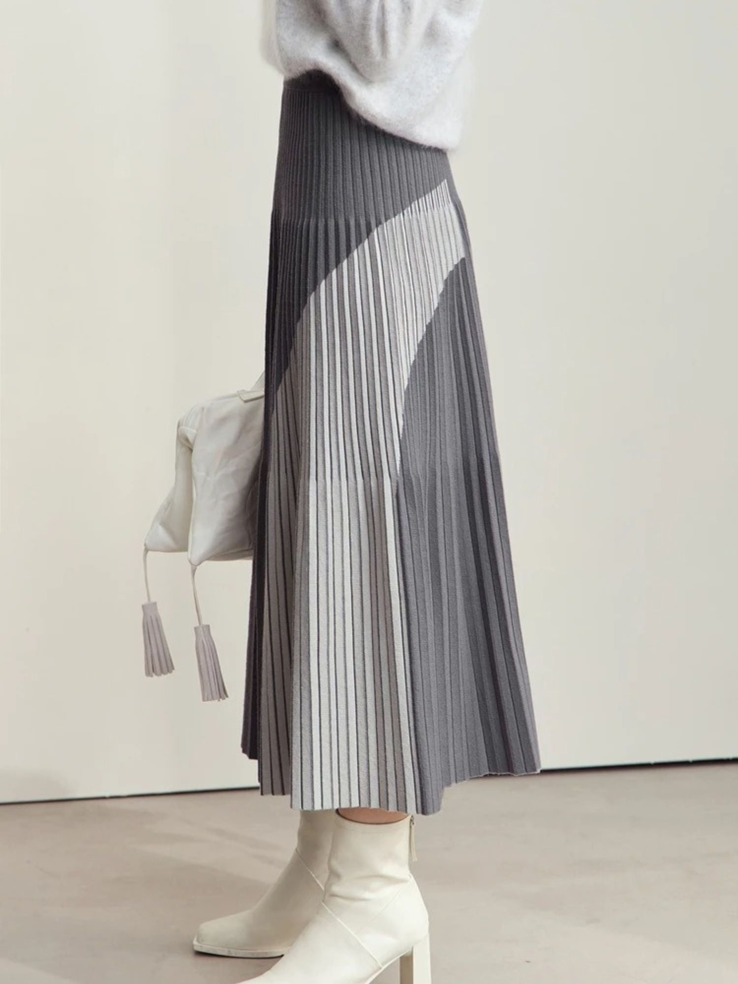 Side view of grey colorblock pleated skirt with white contrast panels
