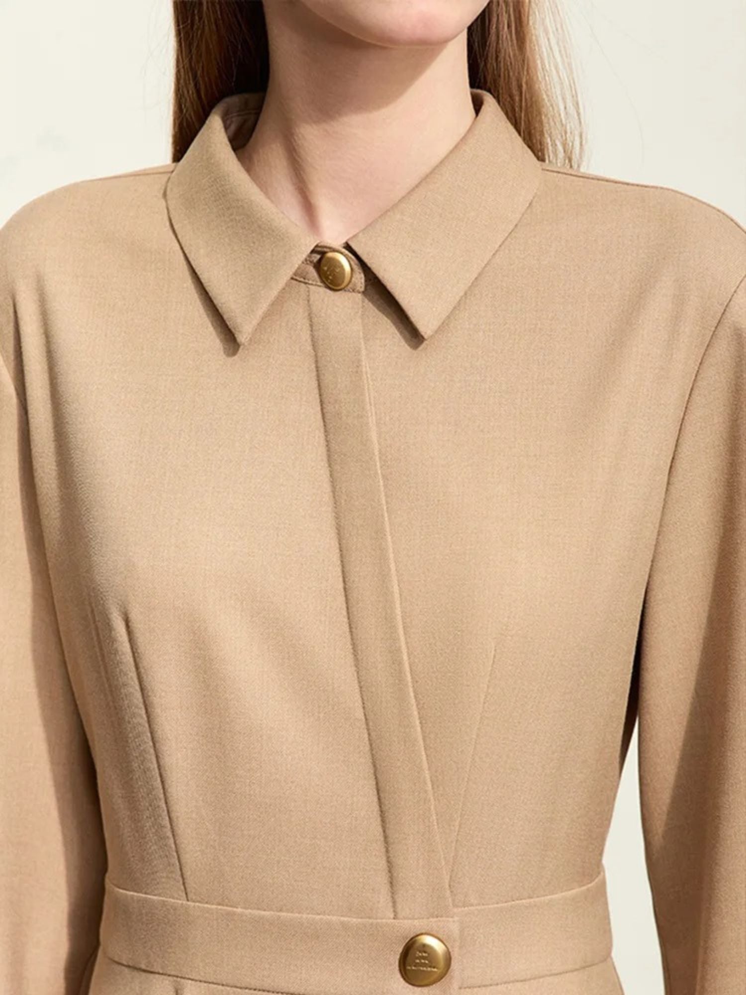 Close-up of camel dress with pleated waist and gold button accent
