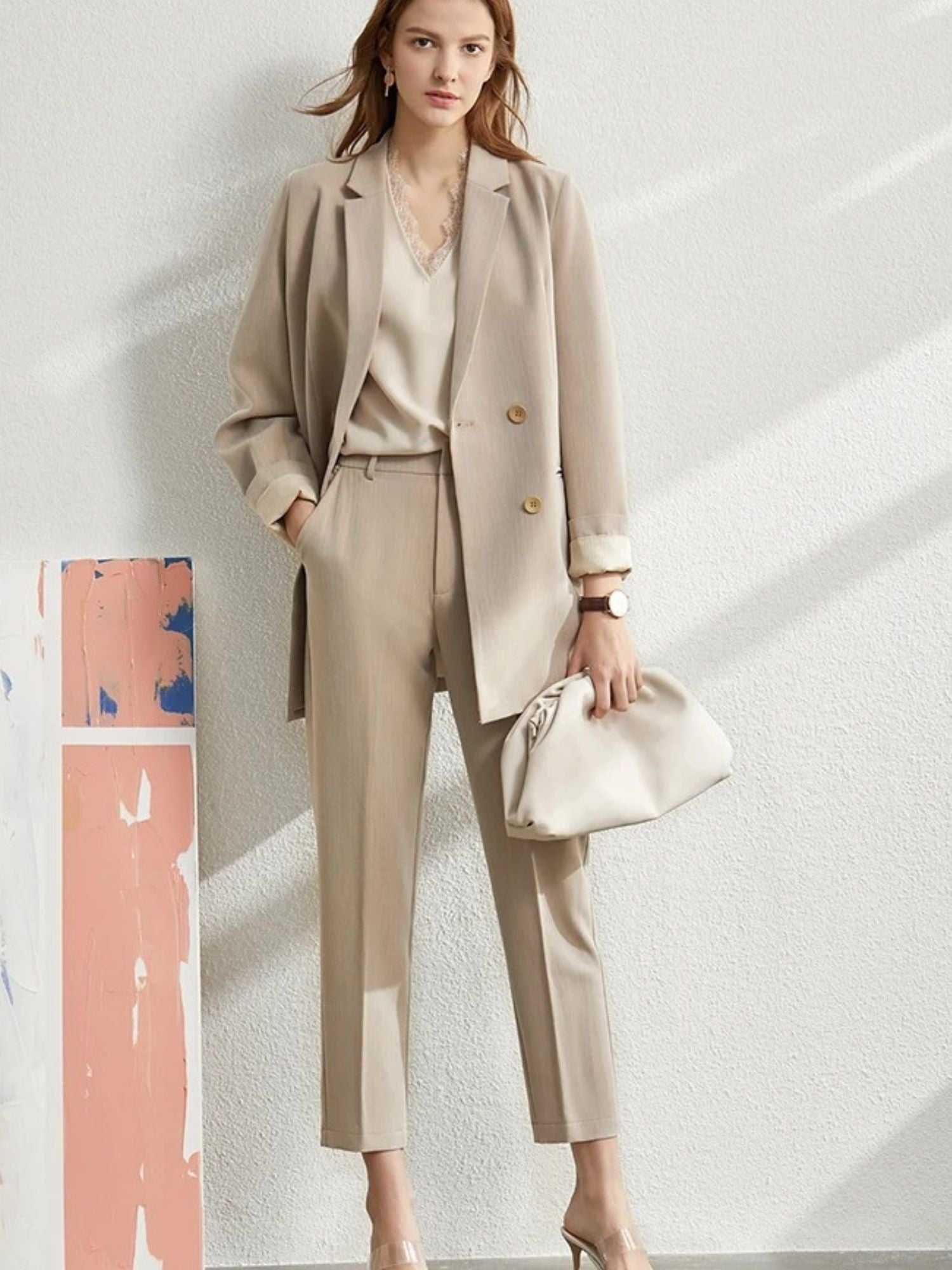 Beige blazer and tapered trousers with white top and structured white handbag