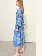 Side profile of blue printed dress with gathered waist and flared hem