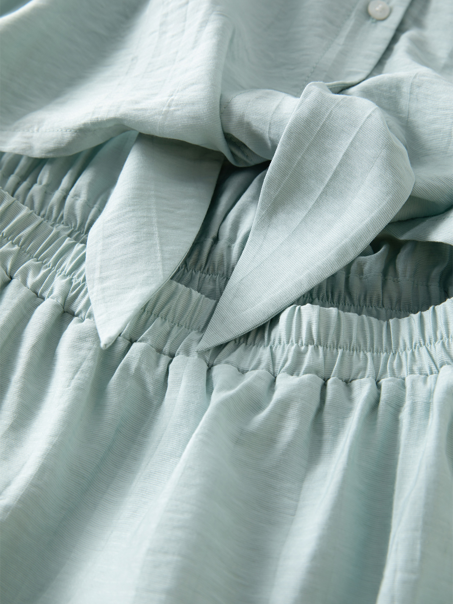 Nahaufnahme der Taillennaht und des Gürtels am mintgrünen Kleid