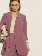 Front view of dusty rose blazer and shorts with striped cuff detail and beige handbag