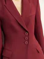 Close-up of burgundy blazer with buttons and sharp tailoring details