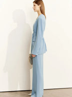 Angled front view of belted light blue blazer paired with matching trousers