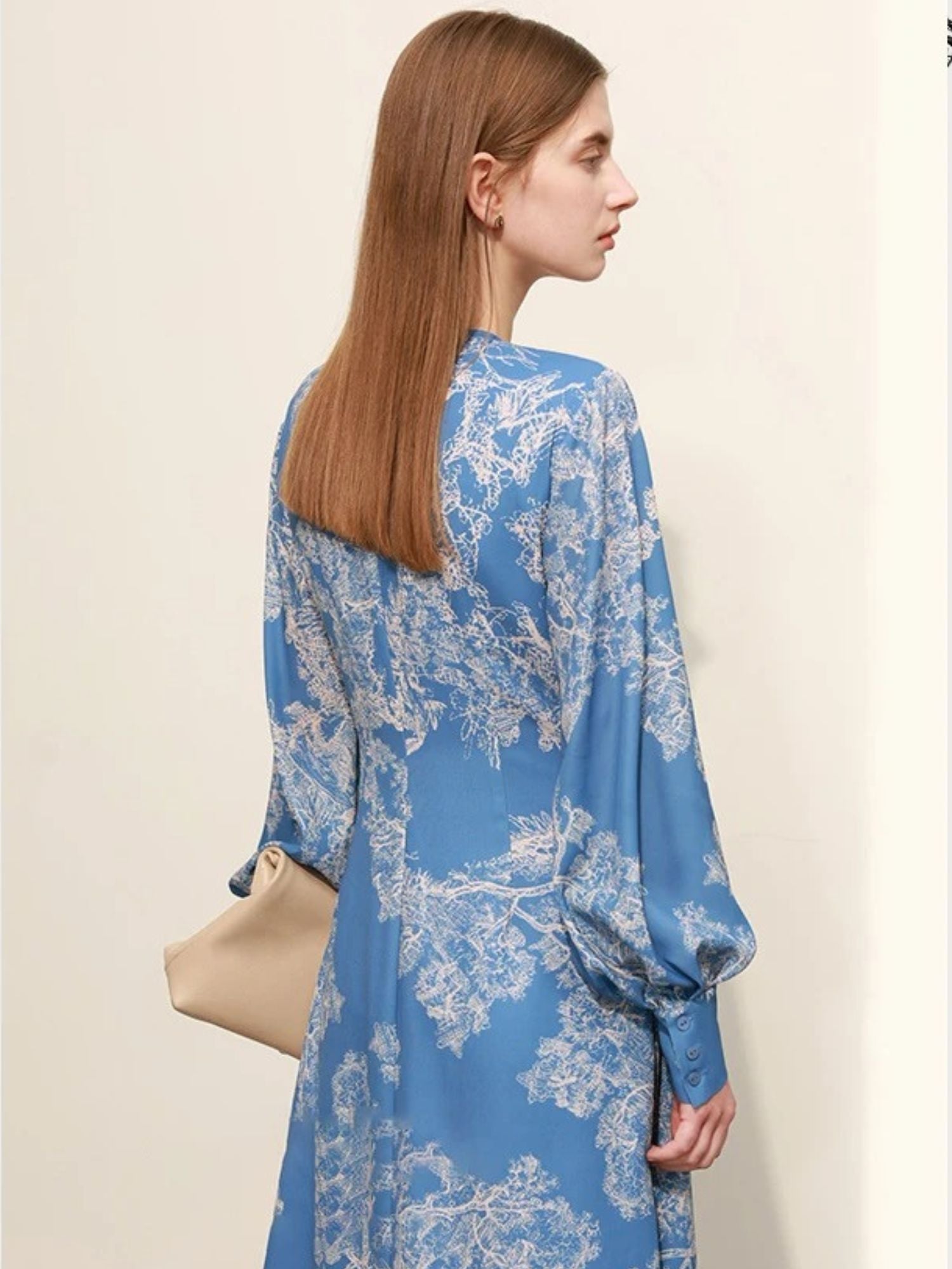 Back view of blue floral midi dress with long sleeves and zip closure