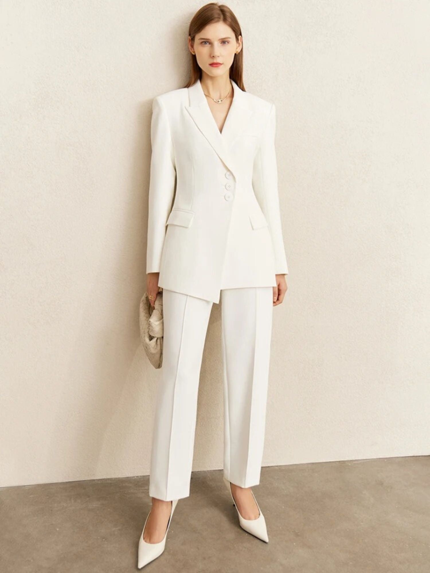 White tailored pantsuit with blazer and wide-leg trousers, styled with nude heels