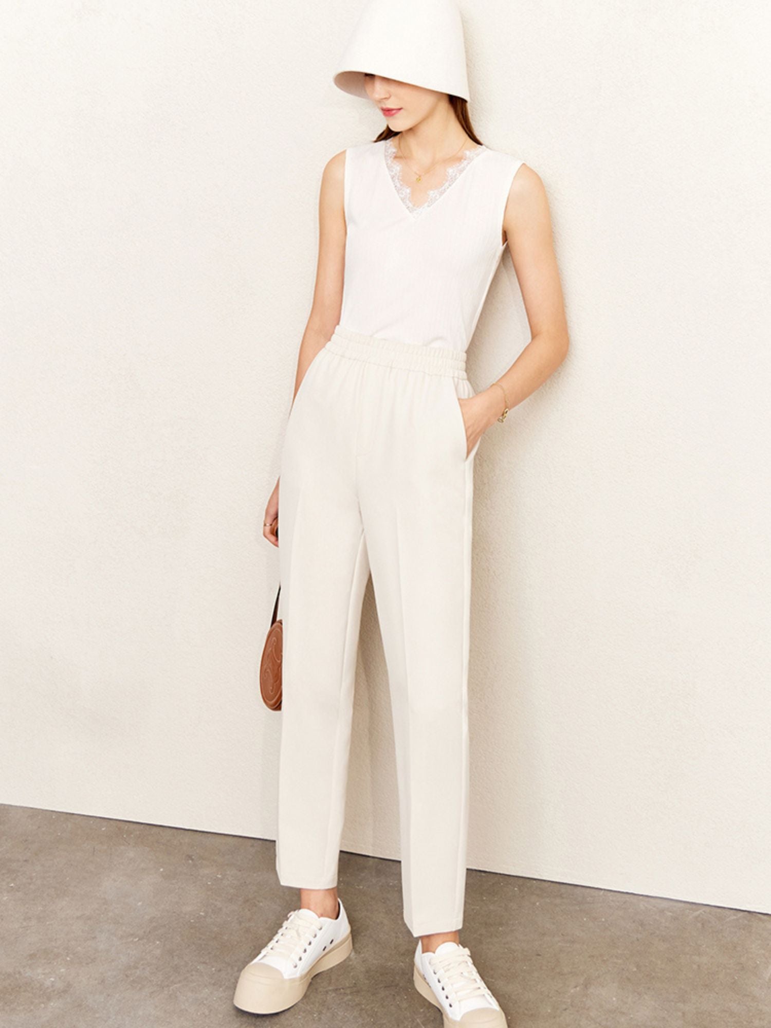 Frau trägt weißes Spitzen-Top in Kombination mit weitem Jumpsuit