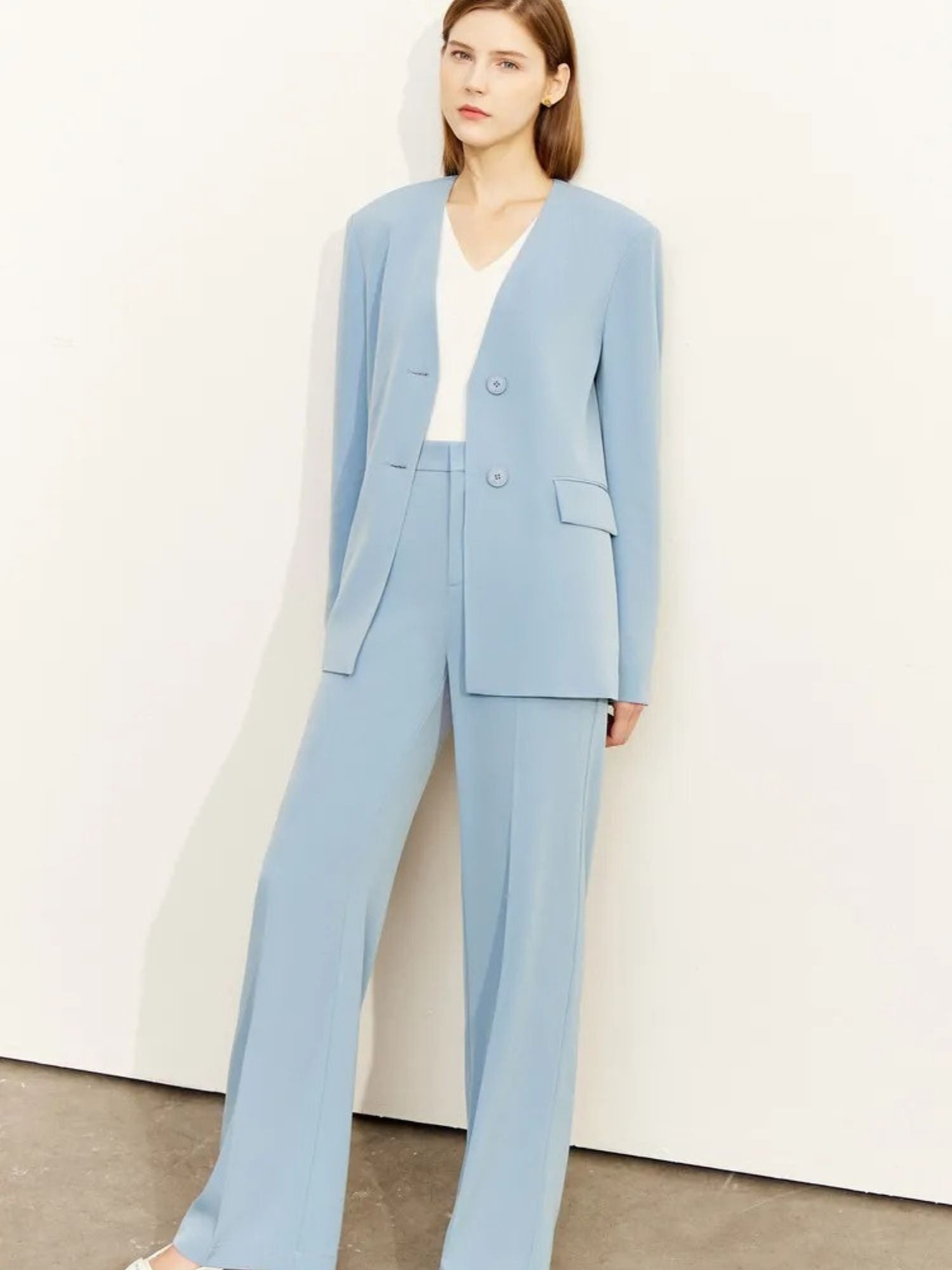 Model in light blue pantsuit with v-neckline blazer and pointed heels