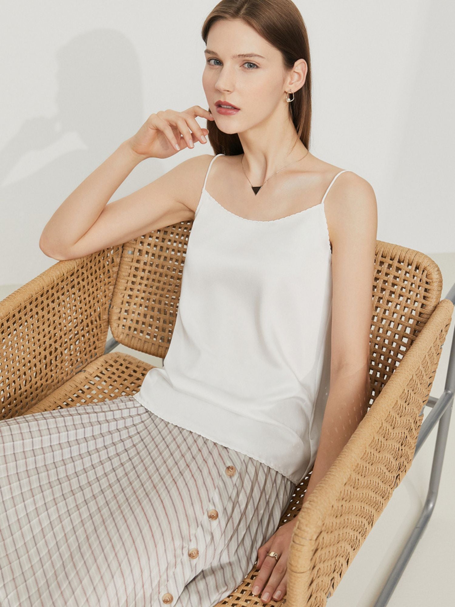 Rückansicht des weißen Satintops beim Sitzen auf einem Rattanstuhl