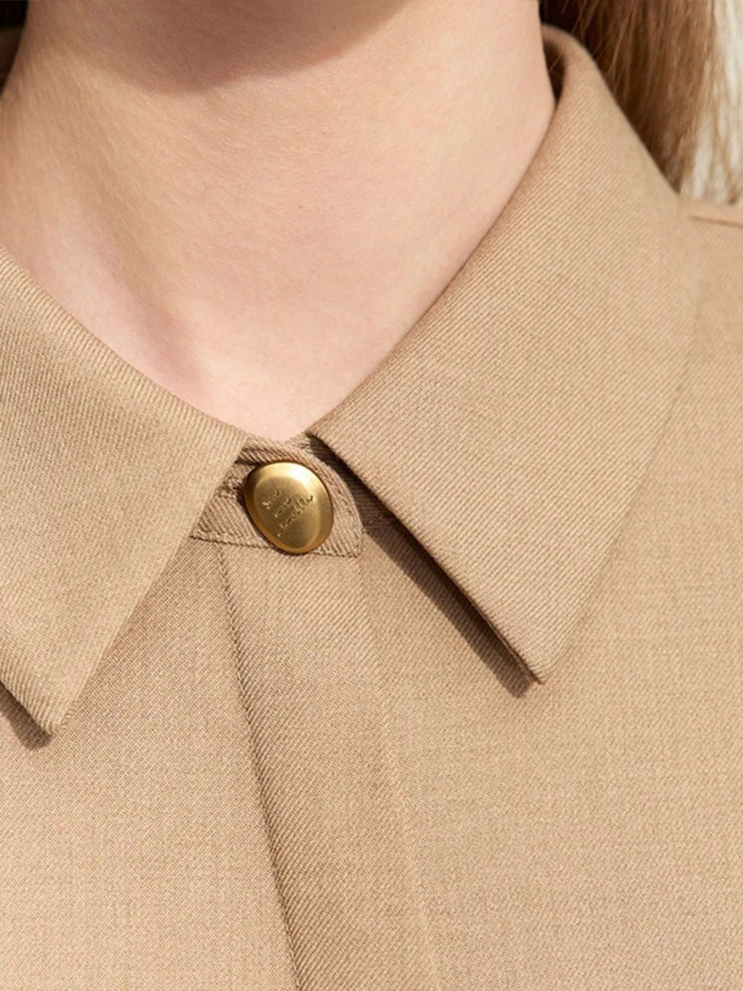 Zoomed-in view of collar and button on camel dress with clean stitching