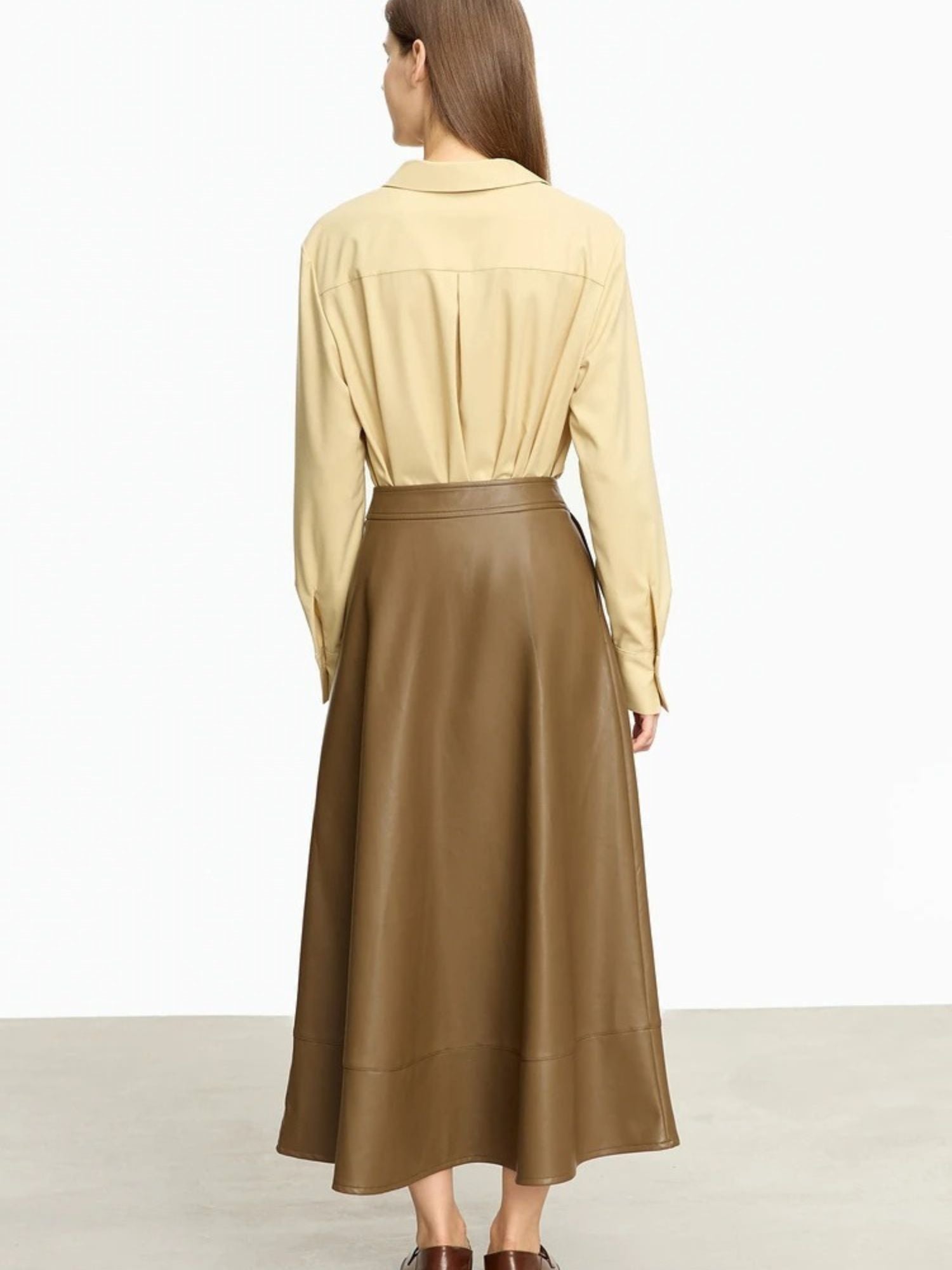 Back view of brown satin skirt with elastic waistband, paired with green knit top