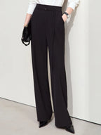 Close-up of black wide-leg trousers with high waist and clean front