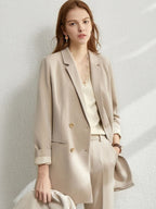 Beige longline blazer with rolled sleeves and matching trousers, styled with crossbody bag
