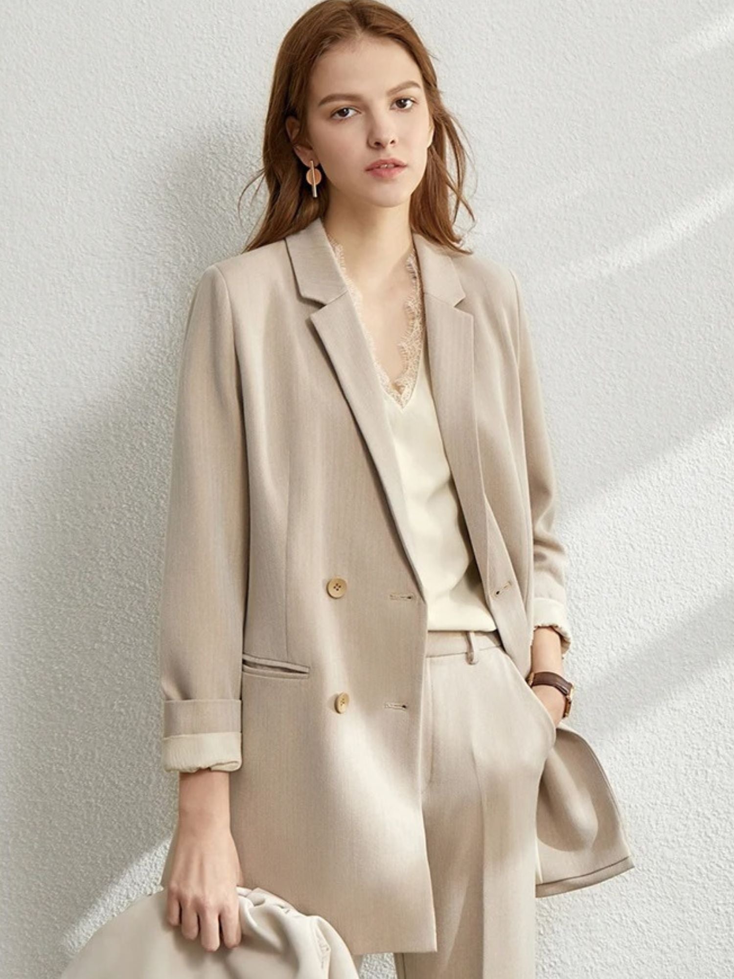 Beige longline blazer with rolled sleeves and matching trousers, styled with crossbody bag