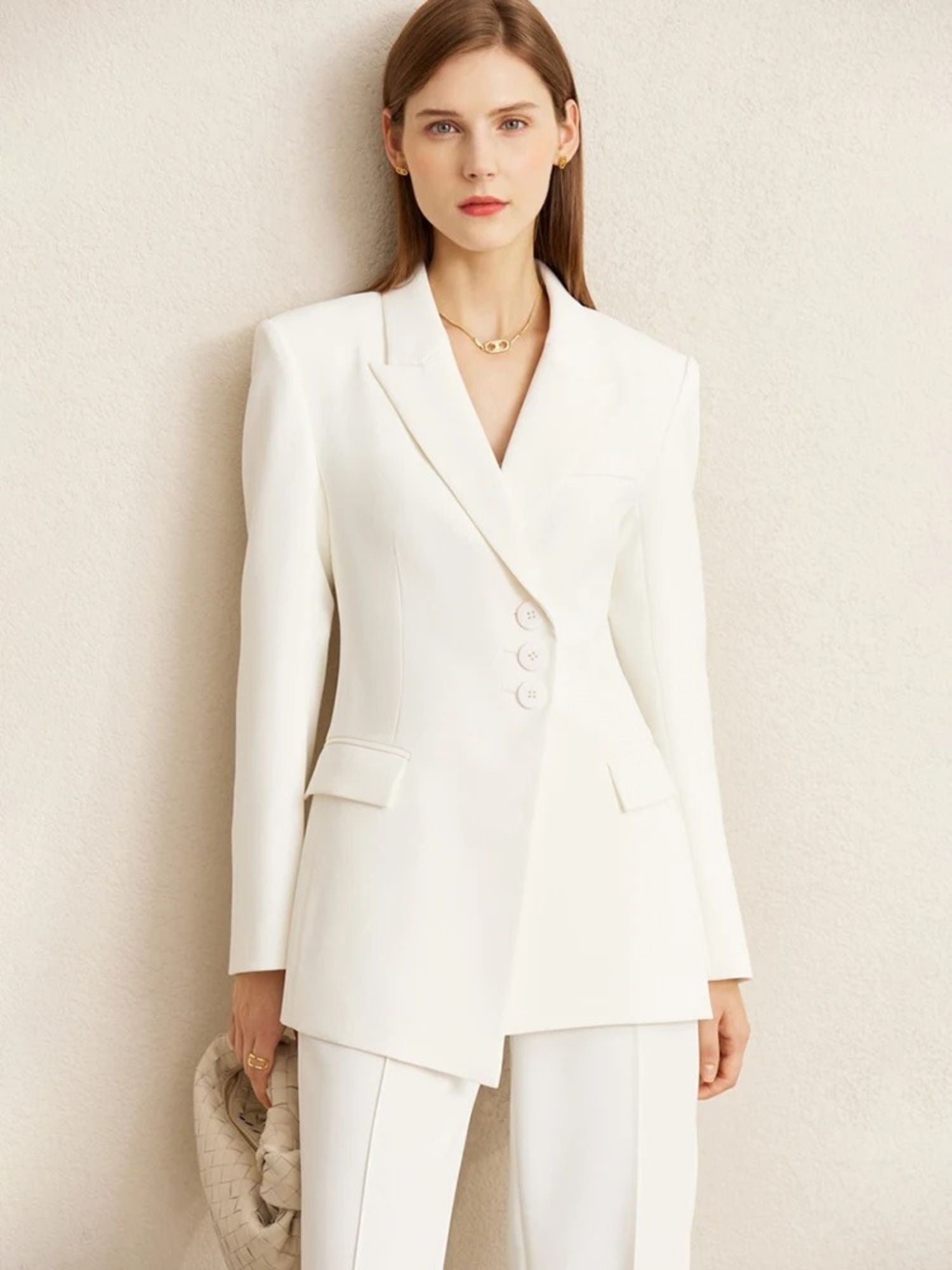 Front view of off-white blazer and matching trousers, styled with green top