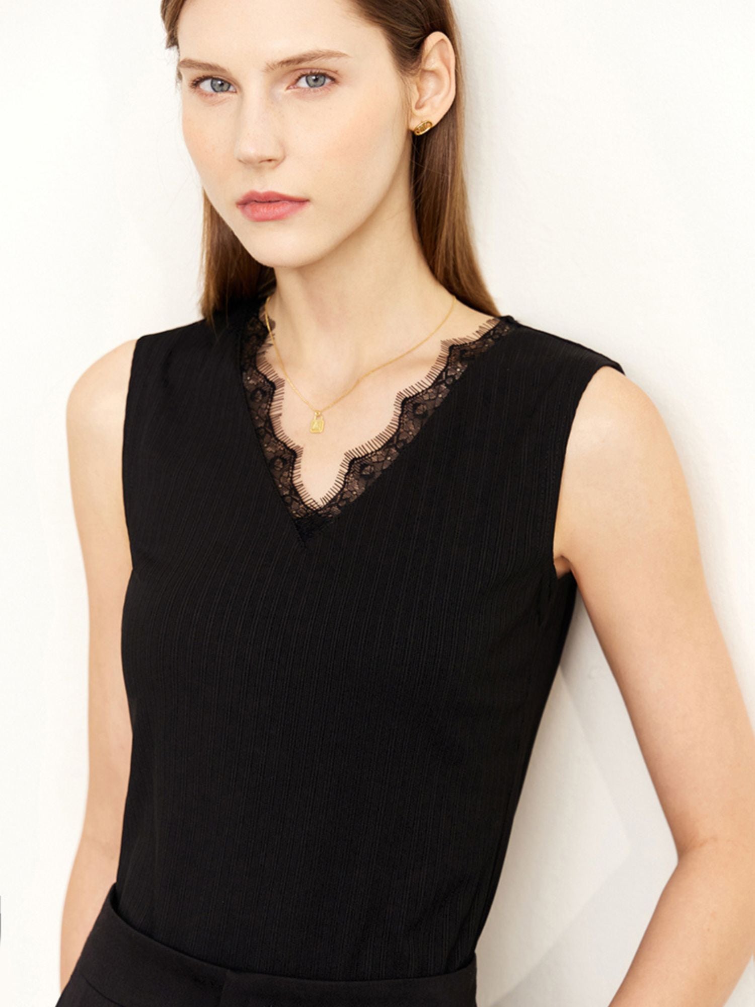 Schwarzes ärmelloses Top mit Spitze am Ausschnitt, von vorne getragen