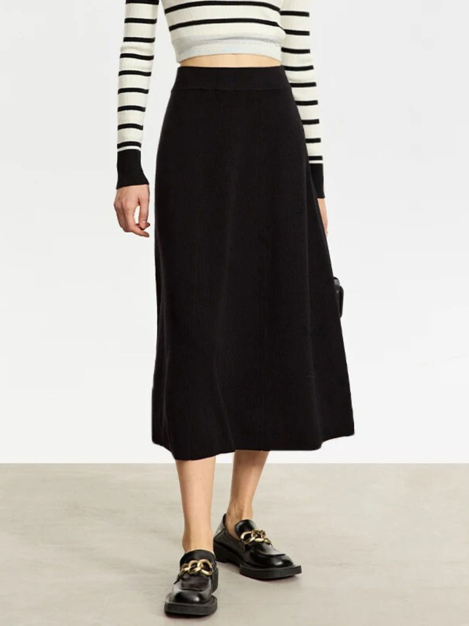 Angled view of black knit skirt with A-line shape and soft texture