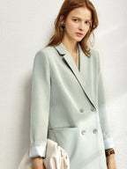 Mint green blazer with double-breasted front and relaxed fit, styled over white blouse