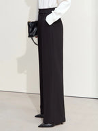 Back view of black trousers with subtle pleats and wide-leg silhouette