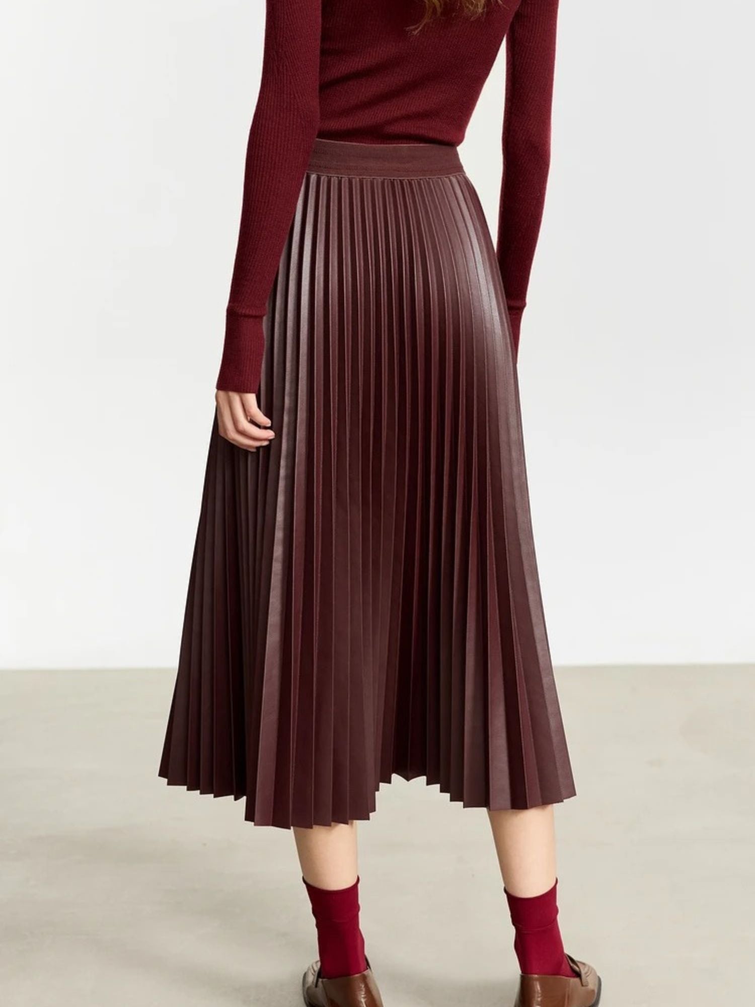 Back view of burgundy pleated skirt with elastic waistband and soft metallic finish