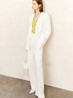 Side profile of white pantsuit with long blazer and flared trousers