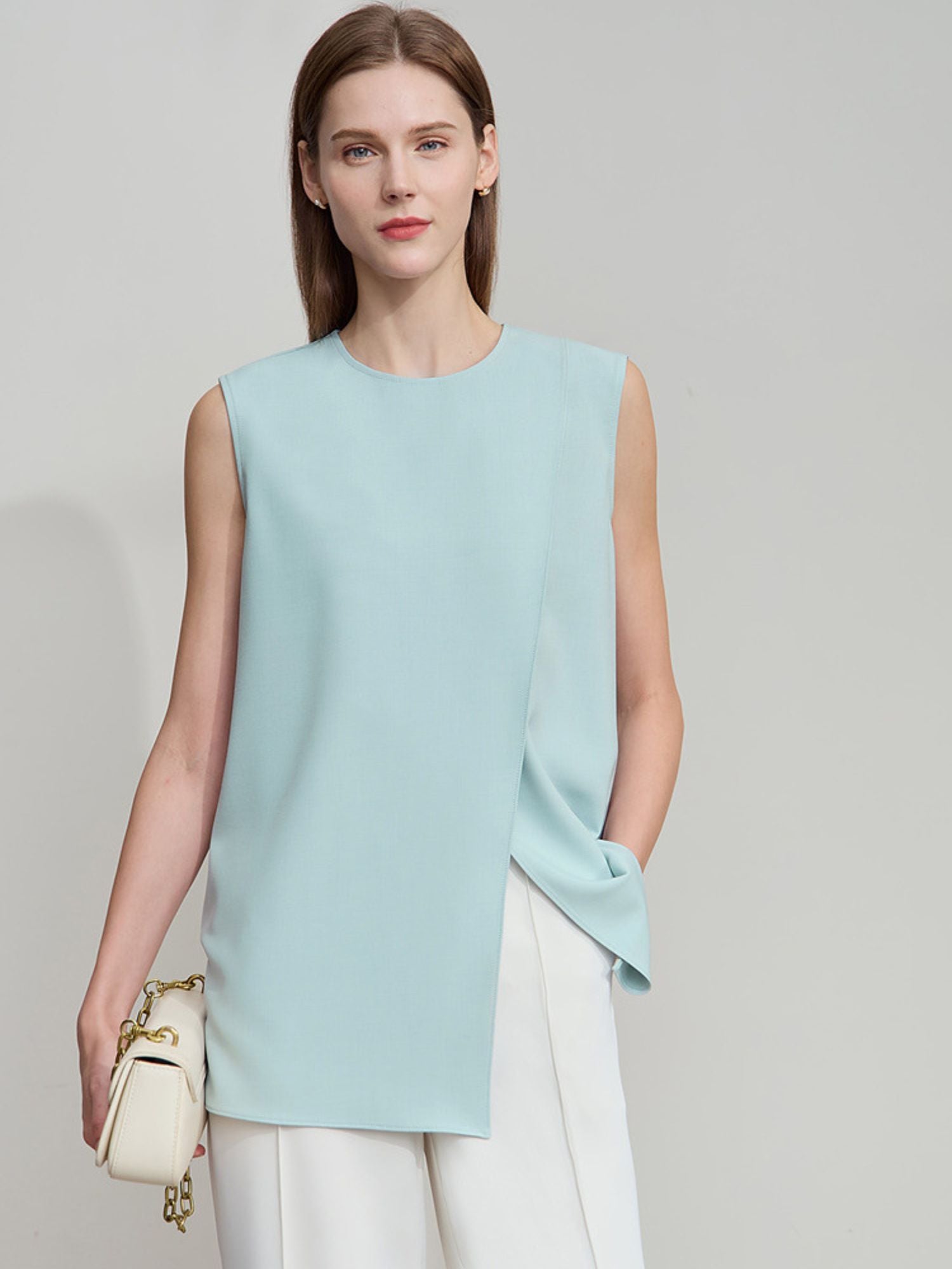 Vorderansicht der blauen ärmellosen Bluse mit lockerer Passform und weißer Hose