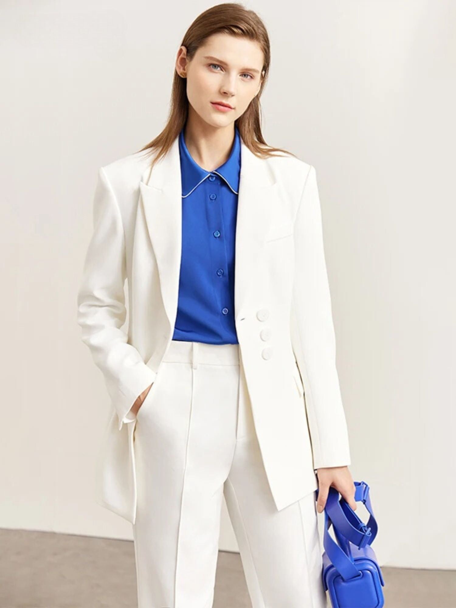 Side profile of white pantsuit with blazer and pleated wide-leg trousers