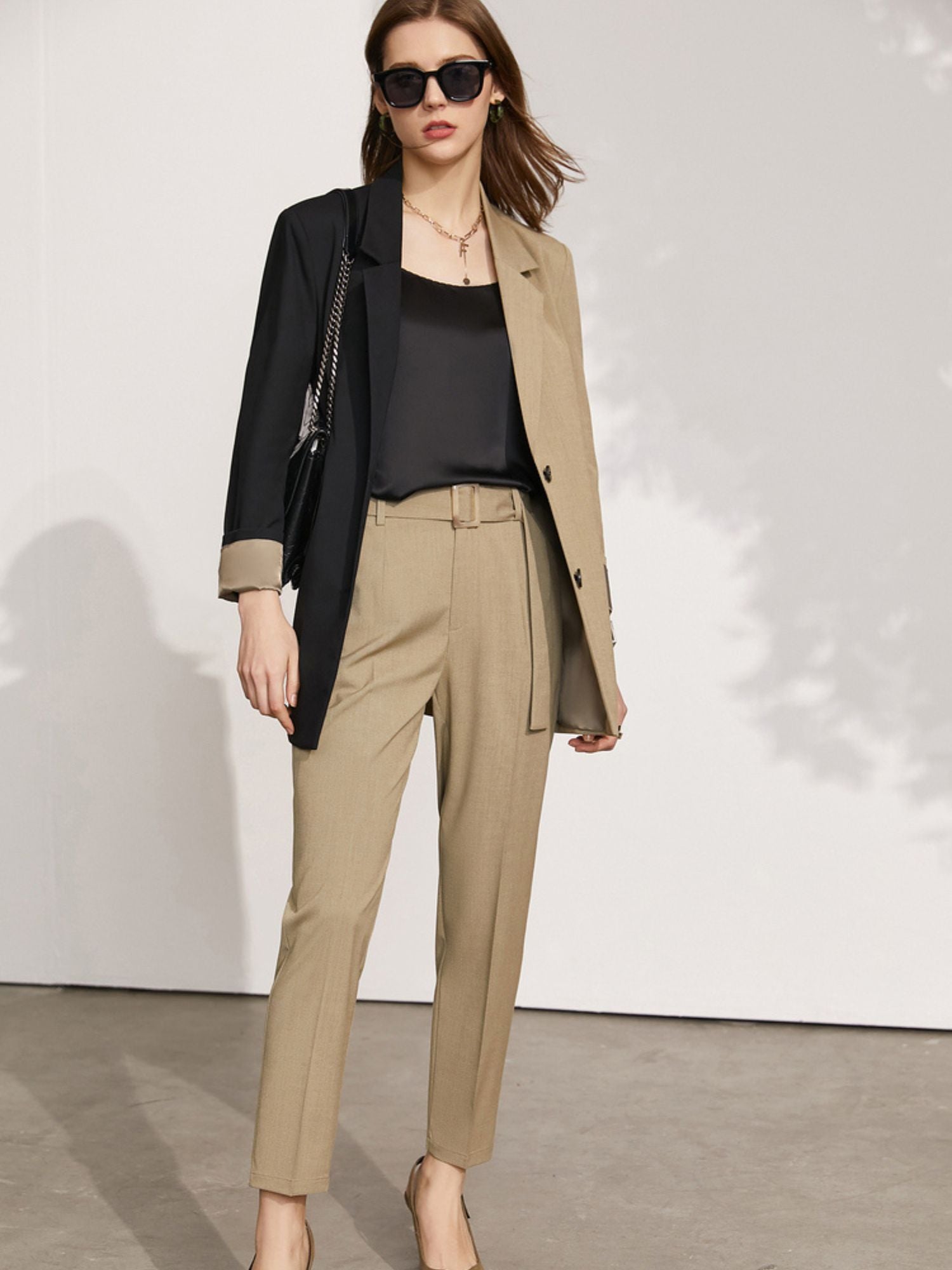 Schwarzes Spaghettiträger-Top mit Sonnenhut und Sonnenbrille, von der Seite fotografiert